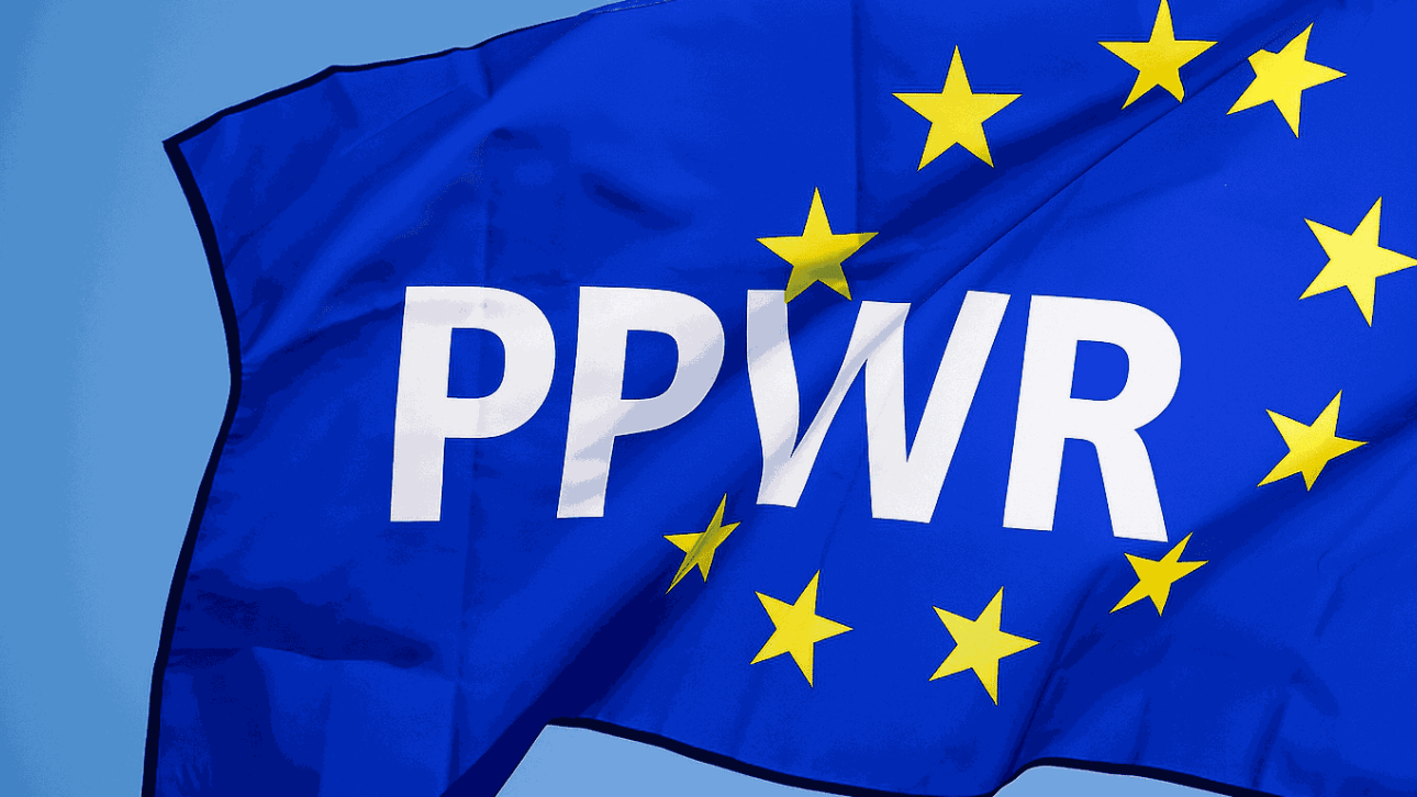 Flaga Unii Europejskiej z białym napisem PPWR na środku, symbolizująca nowe unijne rozporządzenie w sprawie opakowań i odpadów opakowaniowych.