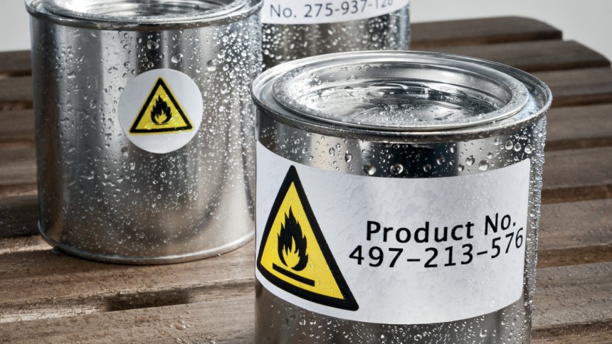 Dwie puszki z materiałymi chemicznymi i żółto-białymi etykietami ostrzegawczymi