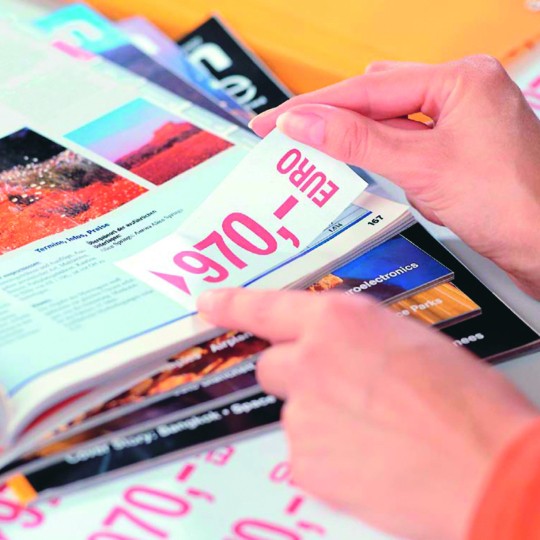 Odklejanie etykiety usuwalnej zawierającej cenę 500 euro z kartki błyszczącego papieru