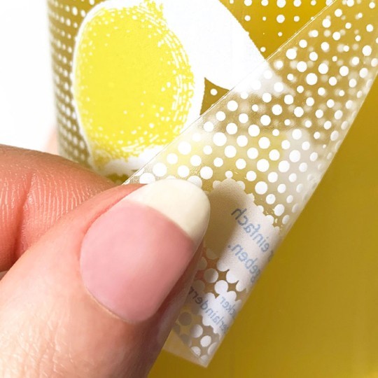 Odklejanie przezroczystej wykropkowanej naklejki z plastikowej powierzchni