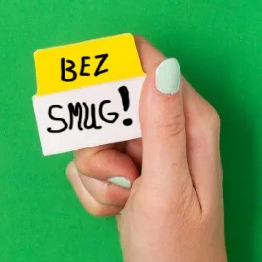 Dłoń trzymająca żółto-białą zakładkę z napisem Bez Smug