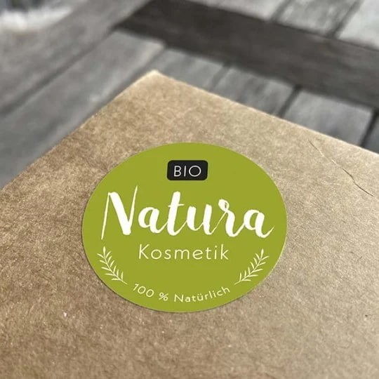 Zielona naklejka z napisem Natura naklejona na kartonową paczkę
