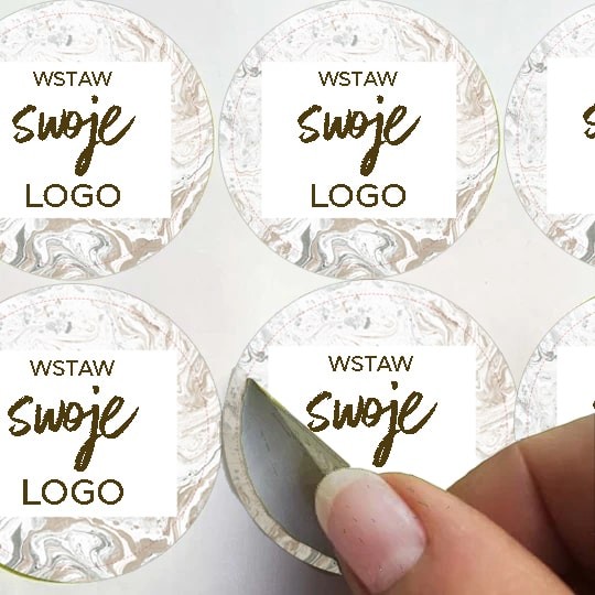 Arkusz okrągłych naklejek z napisem Wstaw Swoje Logo z dłonią odklejającą jedną naklejkę