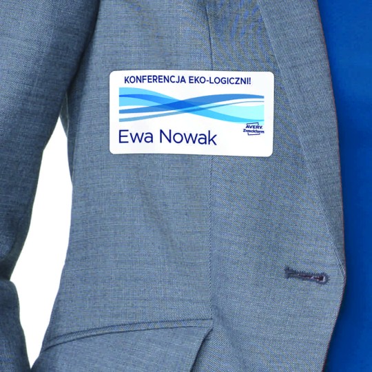 Identyfikator samoprzylepny przyklejony do szarej marynarki z z nadrukiem kilku skrzyżowanych niebieskim linii o różnym natężeniu koloru, logiem Avery Zweckform i podpisem konferencja Eko-logiczni oraz imieniem Ewa Nowak