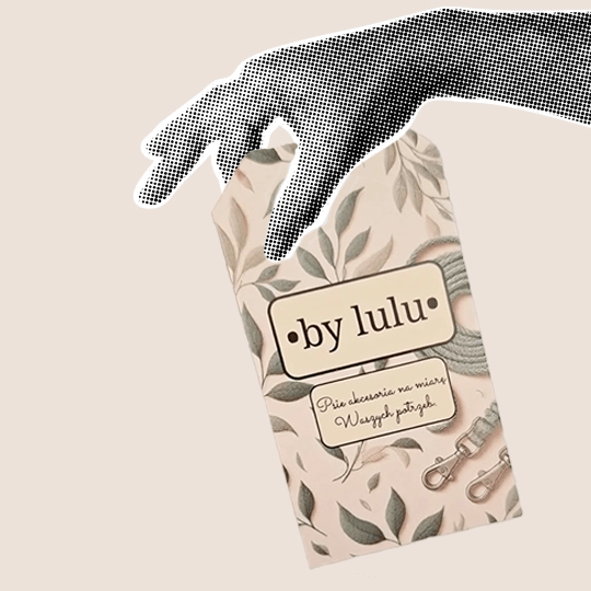 Czarnobiała dłoń trzymająca zawieszkę z napisem By Lulu