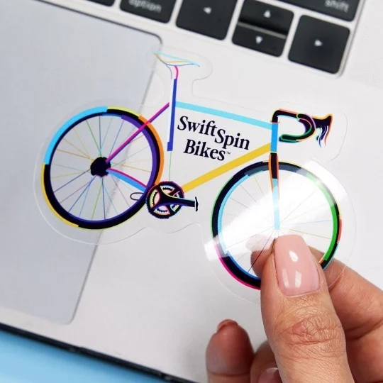 Świecąća kolorowa naklejka w kształcie rowerku z napisem Swift Spin Bikes
