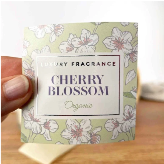 tykieta produktu z napisem „Luxury Fragrance – Cherry Blossom – Organic” na tle wzoru z kwiatami wiśni.