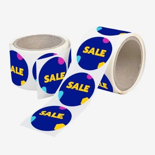 Dwie rolki etykiet samoprzylepnych z okrągłymi granatowymi naklejkami promocyjnymi z napisem SALE