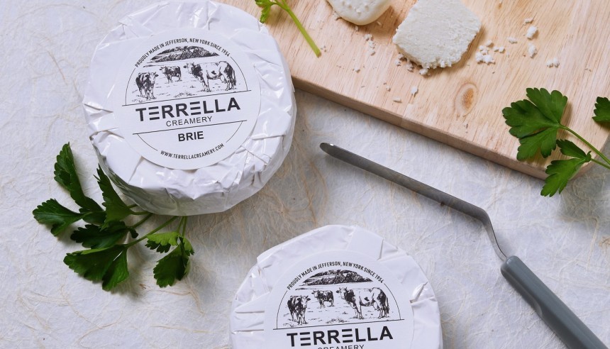 Dwie paczki serka brie z naklejkami z logo