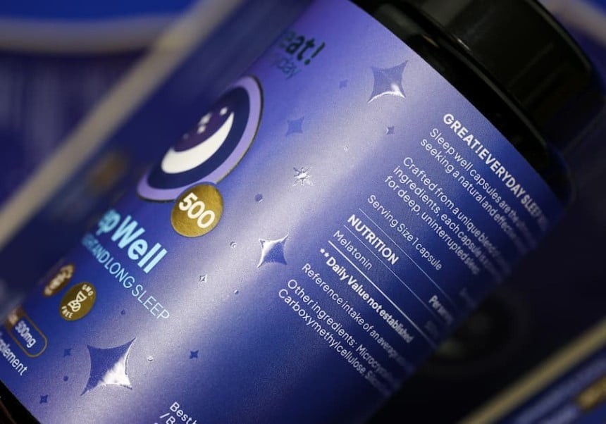 Grafika przedstawia granatową etykietę na ciemnej butelce, na której znajdują się białe napisy, logo i złote elementy graficzne