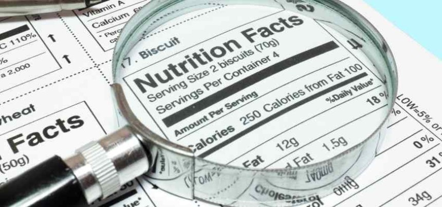 Powiększenie lupą fragmentu tabeli wartości odżywczych na opakowaniu produktu spożywczego, widoczny nagłówek „Nutrition Facts” i niektóre liczby kalorii.