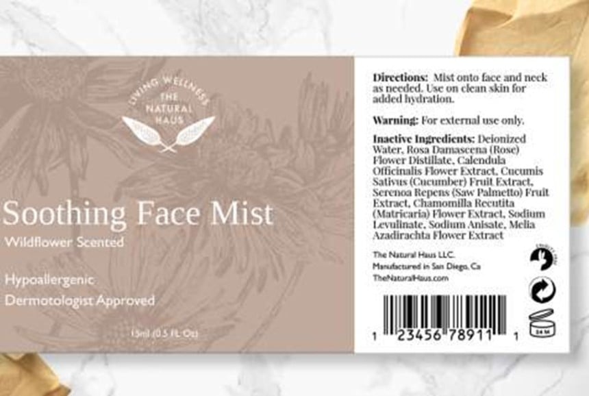 Etykieta produktu "Soothing Face Mist" z informacją o zapachu dzikich kwiatów oraz składem i instrukcją użycia, na tle w odcieniach beżu i bieli z kwiatowym wzorem.