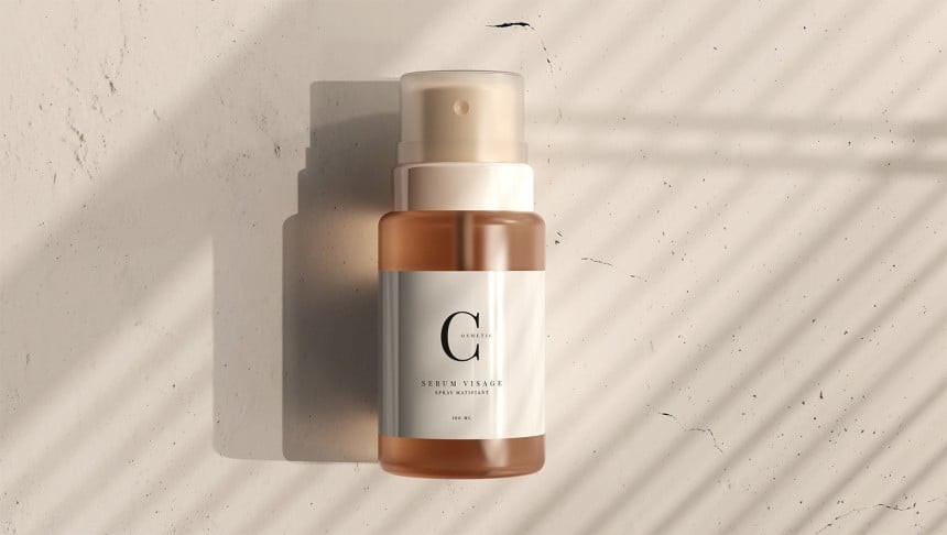 Przezroczysta butelka z pompką, zawierająca kosmetyczne serum do twarzy z białą etykietą i czarnym napisem „Serum Visage”. Produkt stoi na jasnej, lekko popękanej powierzchni, oświetlonej promieniami światła przechodzącego przez żaluzje.