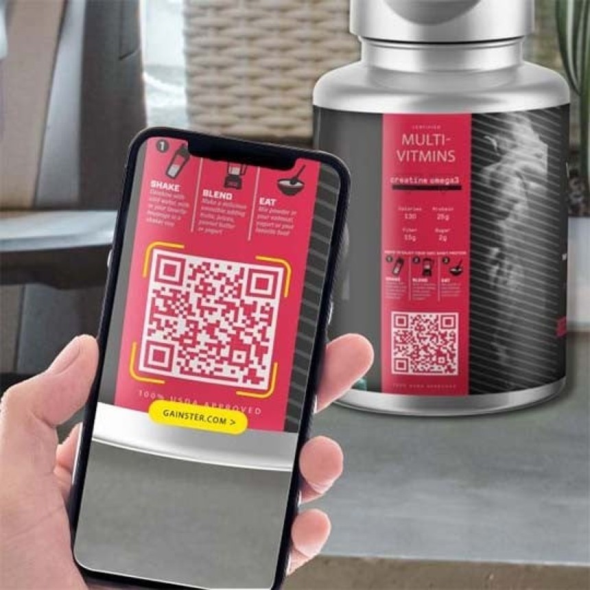 Dłoń trzymająca smartfon z włączonym aparatem skanującym duży czerwony kod QR na etykiecie suplementu diety, w tle widoczna butelka z tą samą etykietą, co pokazuje użycie kodu do uzyskania informacji o multiwitaminach