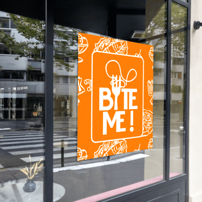 Pomarańczowy plakat na szybie z dużym napisem: „BITE ME!”