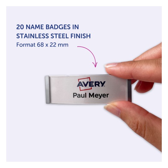 Obraz przedstawiający plakietkę z nazwiskiem ze stali nierdzewnej z tekstem 'Avery Paul Meyer'. Plakietka jest trzymana przez rękę osoby. Tło jest jasnofioletowe, a wymiary plakietki to 68 x 22 mm.