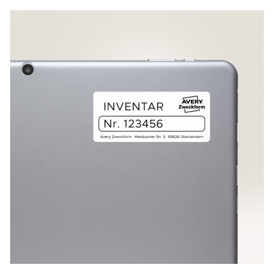 Obraz przedstawia tył tabletu lub laptopa z etykietą. Na etykiecie widnieje napis 'INVENTAR Nr. 123456', wskazujący na informacje inwentarzowe, oraz znajduje się nazwa marki 'Avery Zweckform' wraz z adresem.