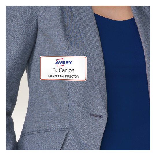 Obraz przedstawia osobę w szarej marynarce z identyfikatorem, na którym widnieje napis „B. Carlos, Dyrektor Marketingu” oraz logo firmy Avery.