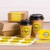 Arkusz żółtych okrągłych etykiet oraz paczki na żywność i plastikowe kubeczki zawierające te etykiety