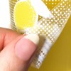 Odklejanie przezroczystej wykropkowanej naklejki z plastikowej powierzchni