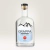 Butelka przezroczystego napoju z biało błękitną naklejką z motywem gór oraz napisem Grappa