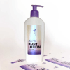 Butelka płynu do kąpieli z fioletową pompką, srebrnofioletową naklejki z efektem masy perłowej z napisem aura body lotion, położona na arkuszu naklejek