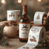 Butelka z brązowego szkła z etykietą świąteczną „Christmas” stoi na drewnianym stole w otoczeniu świątecznych dekoracji. Obok znajduje się rolka naklejek z bożonarodzeniowymi motywami, m.in. choinką i czerwonym samochodem z choinką na dachu. W tle widoczne są kolejne rolki z naklejkami i świąteczne ozdoby.