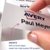 Obraz pokazuje dłoń trzymającą białą kartę z nazwiskiem 'Paul Meyer' i logo marki 'Avery'. Karta opisywana jest jako mająca gładkie krawędzie i wykonana z wysokiej jakości papieru.