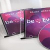 Obraz przedstawia dwa pudełka na płyty CD z tytułem „Sales Meeting” oraz płytę z kolorowym designem. Projekt zawiera okręgi w odcieniach różu i fioletu oraz tekst „beEven.”