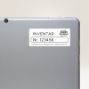 Obraz przedstawia tył tabletu lub laptopa z etykietą. Na etykiecie widnieje napis 'INVENTAR Nr. 123456', wskazujący na informacje inwentarzowe, oraz znajduje się nazwa marki 'Avery Zweckform' wraz z adresem.