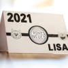 Obrazek przedstawia kartkę z rokiem 2021, napisem 'FROHES NEUES' oraz imieniem 'LISA'. Po obu stronach centralnego tekstu znajdują się rysunkowe ilustracje kotów.