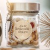 Obrazek przedstawia szklany słoik wypełniony świątecznymi ciasteczkami, z etykietą w języku niemieckim 'Aus der Weihnachtsbäckerei', wskazującą, że pochodzą z bożonarodzeniowej piekarni. Słoik jest elegancko ozdobiony wstążką, a w pobliżu znajdują się dekoracyjne elementy, w tym ozdoba w kształcie gwiazdy.